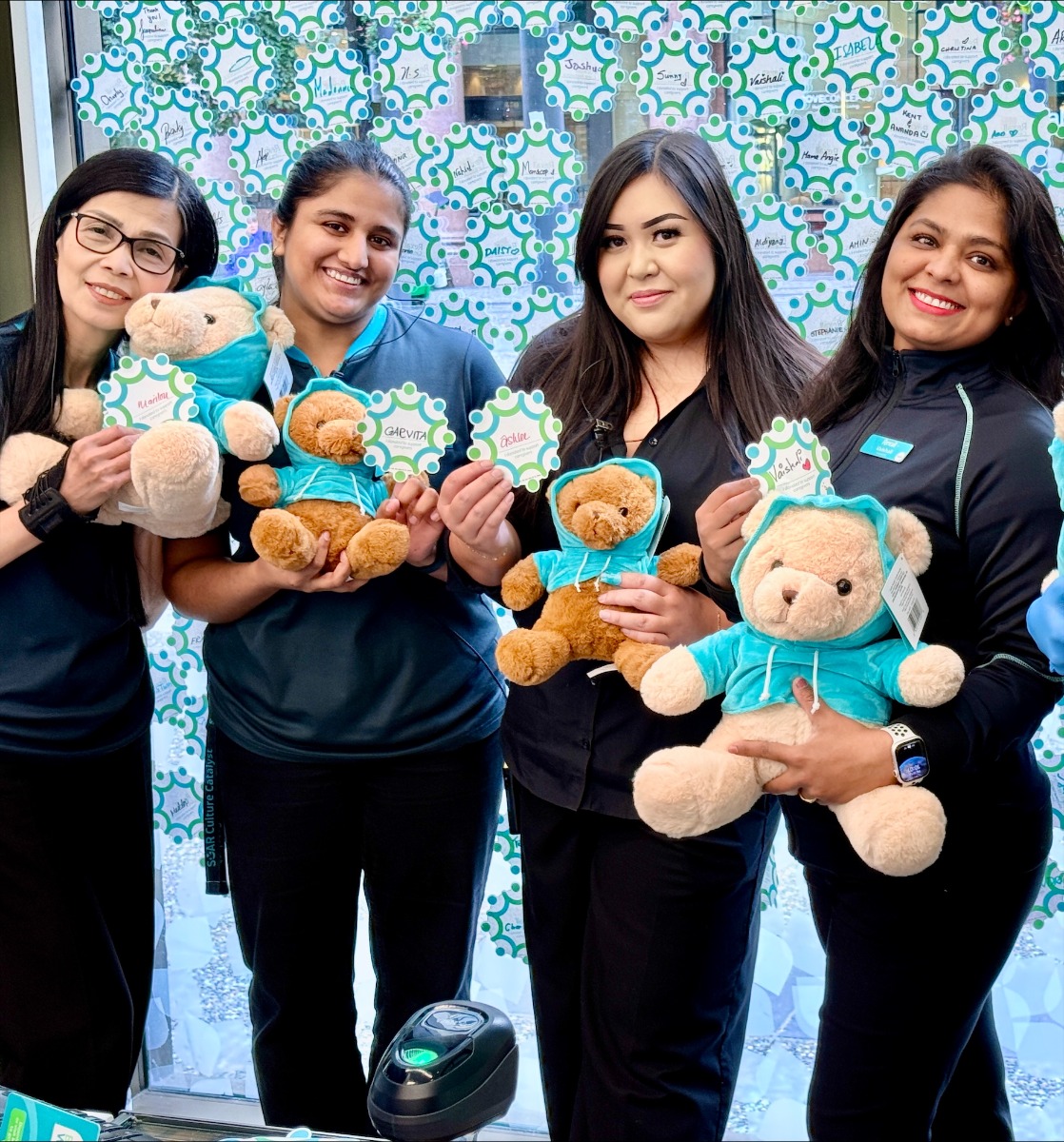 Rexall team members holding Care Network teddy bears.