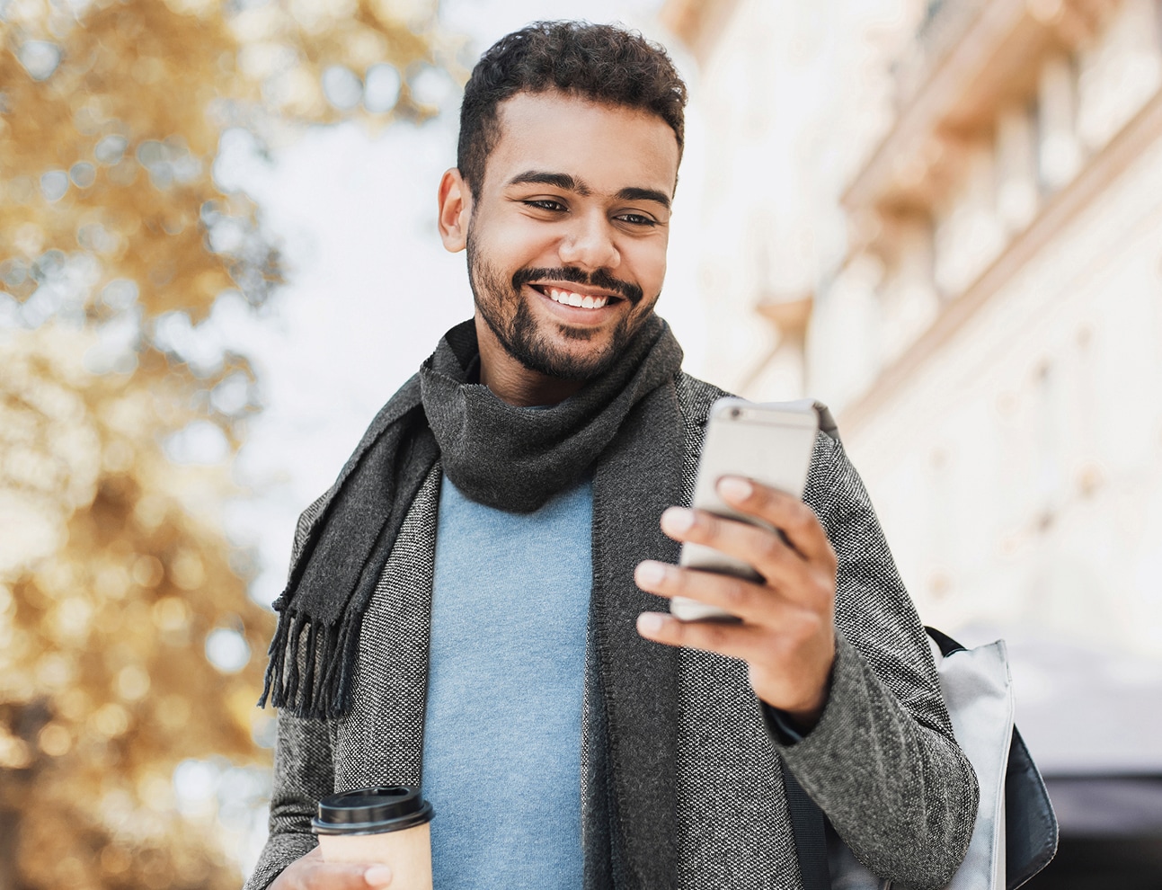 Man with scarf holding hot drink